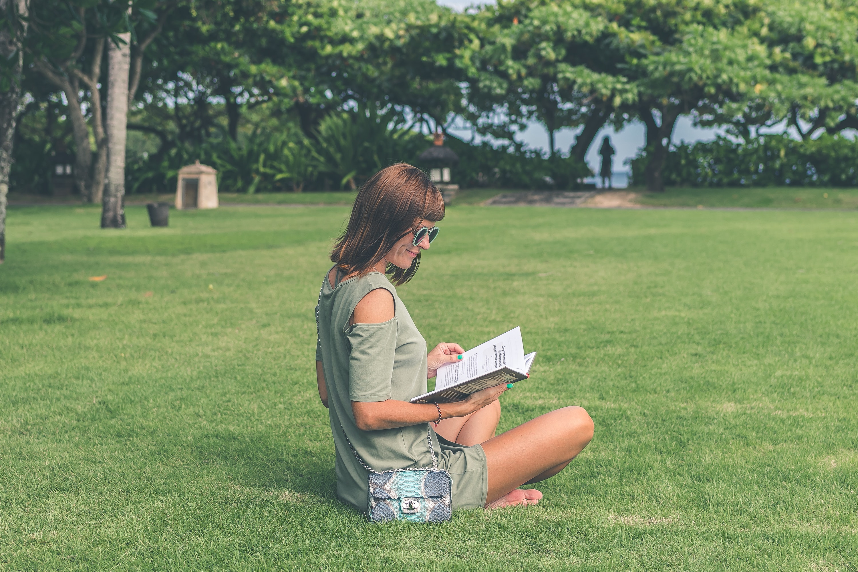 estudante lendo seu livro sentada na grama